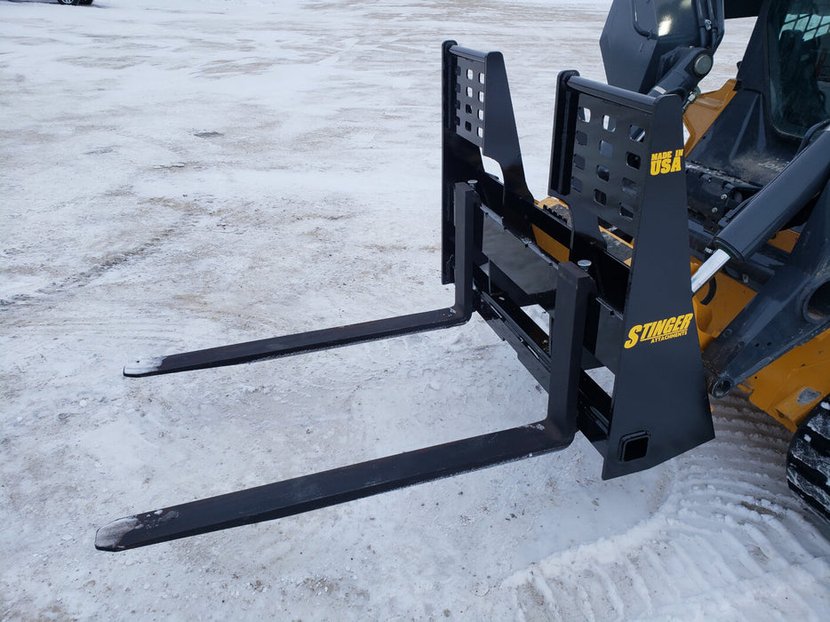 Skid steer pallet forks by Stinger lifting pallet of bricks – perfect attachment for construction, warehouse, and agricultural work.