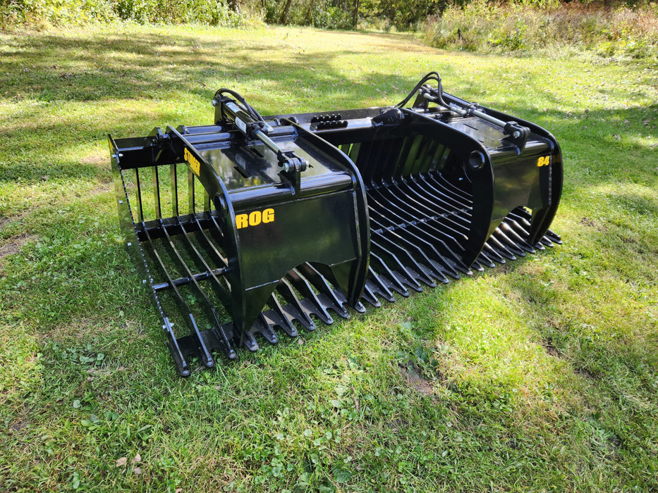 Operator using Stinger skid steer grapple bucket to remove rocks and roots – durable attachment built for construction and landscaping.