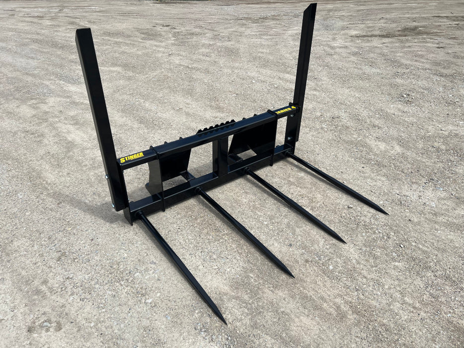 Stinger bale spear penetrating tightly packed hay bale – strong, reinforced tines ensure stability and control during handling.