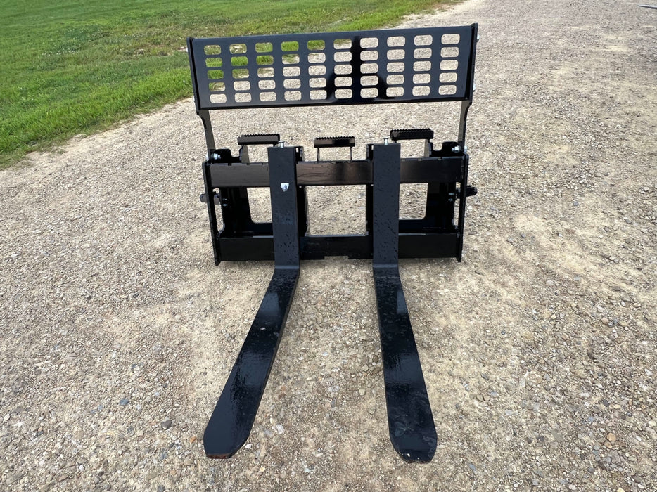 Heavy-duty skid steer pallet forks by Stinger lifting hay bales – powerful hydraulic mechanism allows smooth and accurate control.