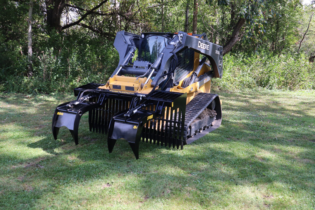 Heavy-duty Stinger open-side skid steer grapple bucket clearing field debris – powerful attachment built for efficiency and durability.