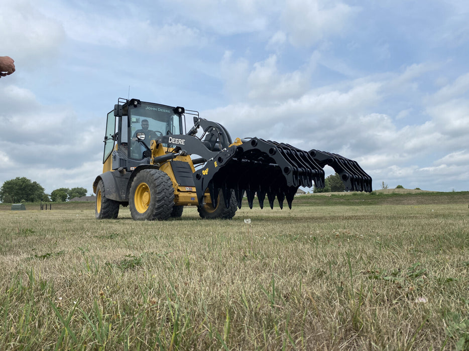 Utility tractor equipped with a tractor grapple bucket handling rocks, brush, and large materials efficiently.