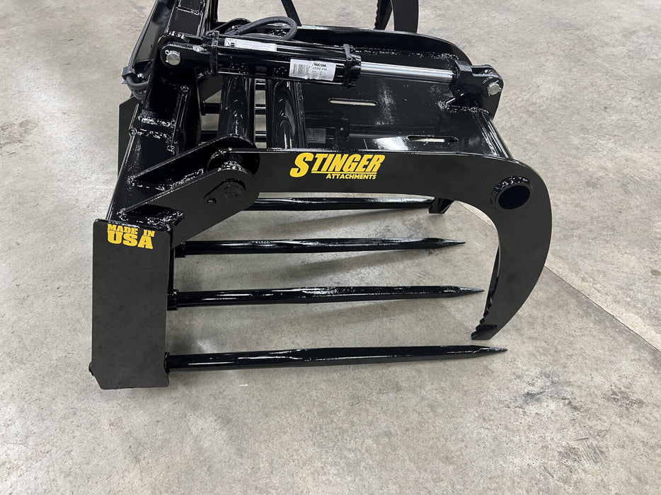 Durable Stinger skid steer manure grapple scooping hay and debris – perfect for clearing feedlots, barns, and corrals.