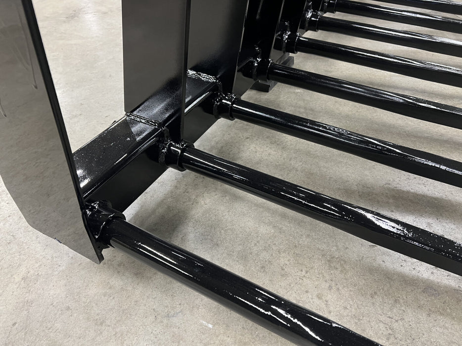 Stinger skid steer manure grapple attached to loader moving mixed debris – versatile attachment for efficient farm waste management.