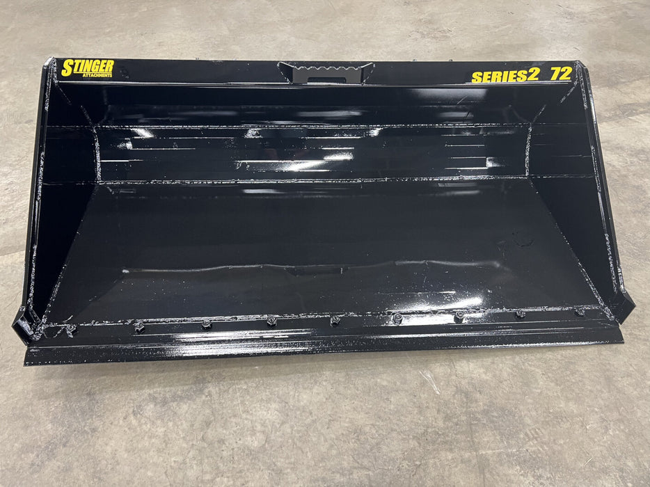 Heavy-duty skid steer material bucket by Stinger scooping dirt and sand – durable Series 2 design for maximum strength and capacity.