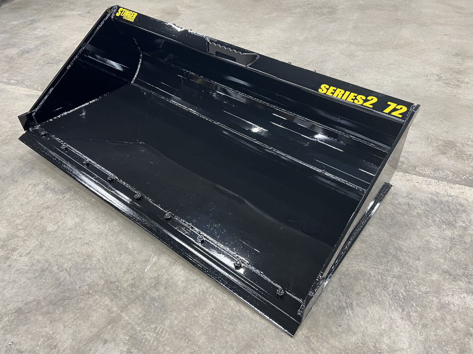Stinger Series 2 heavy-duty skid steer material bucket attached to loader – rugged construction ensures reliability in tough conditions.