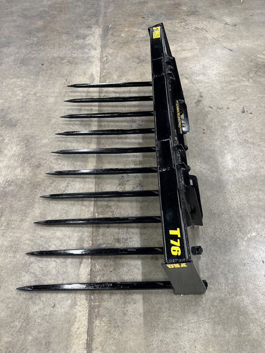 Rugged Stinger skid steer grapple bucket with manure spears clearing barn waste – professional-grade farm tool for efficient material handling.
