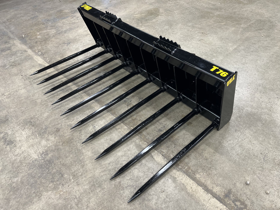 Heavy-duty skid steer grapple bucket by Stinger managing hay and manure – strong, reinforced frame ensures stability and control.