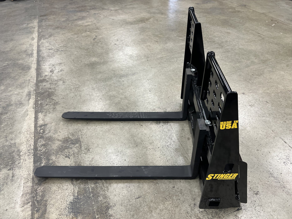 Heavy-duty skid steer pallet forks by Stinger handling heavy loads – ideal for farming, landscaping, and industrial applications.
