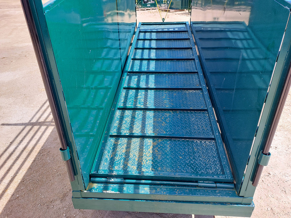 Farm worker adjusting the Lakeland portable loading chute for cattle to align with livestock trailer