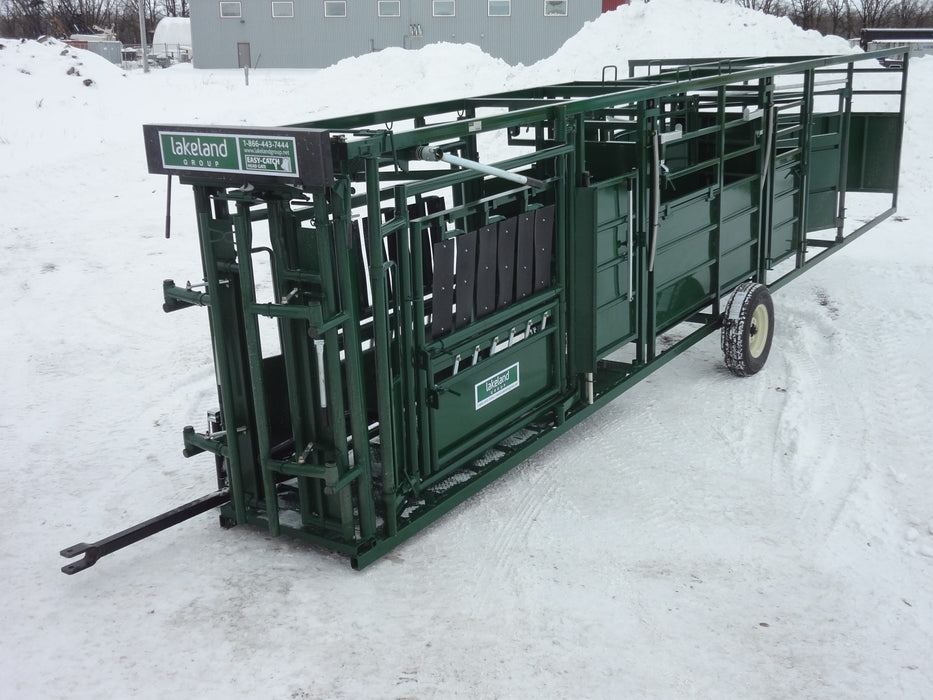 Farmer guiding livestock through Lakeland’s Cattle Squeeze Chute and alley setup on open pasture