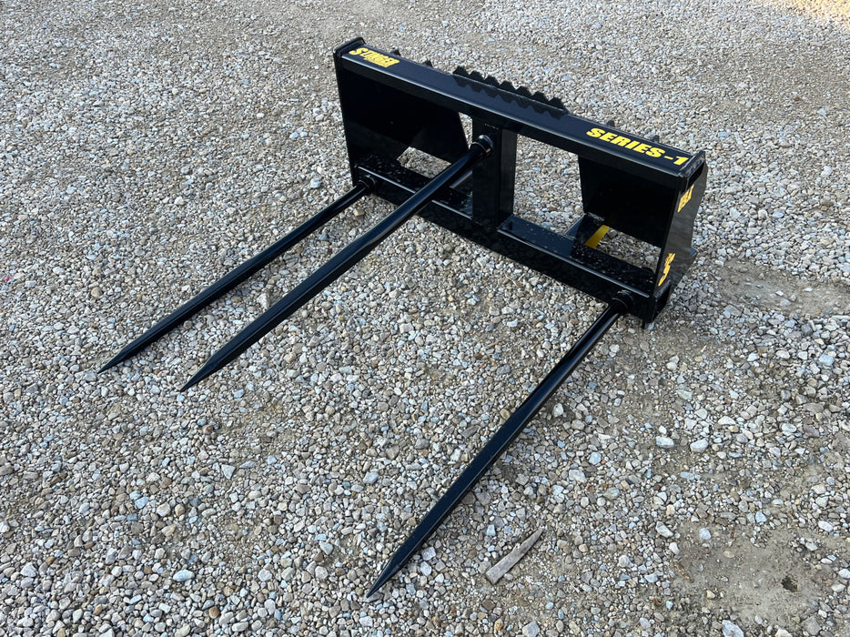 Series 1 standard bale spear from Stinger Attachments mounted on tractor – strong, efficient tool for transporting and stacking hay bales.