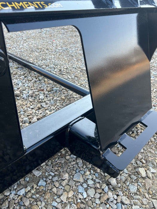 Stinger Series 1 bale spear attached to skid steer carrying compacted hay bale – rugged construction ensures stability and control.