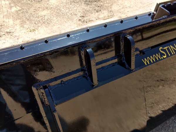 Stinger skid steer material bucket dumping rocks and soil – high-capacity Series 3 model built for power and precision.