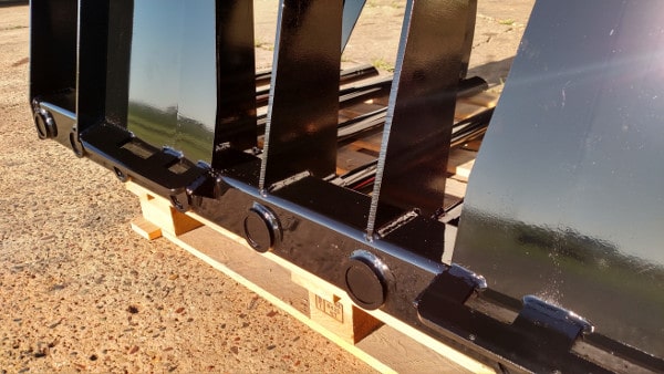 Front view of Stinger manure tine grapple bucket mounted on skid steer – durable tool designed for strength and versatility.