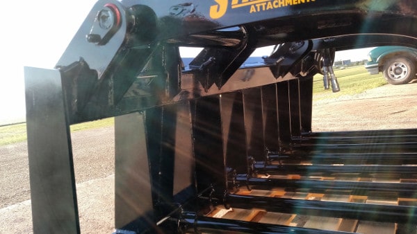 Stinger heavy-duty skid steer grapple bucket lifting hay and feed waste – optimized for maximum load capacity and smooth operation.