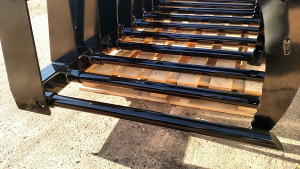 Stinger manure tine skid steer grapple bucket clearing livestock pens – professional-grade tool for fast and reliable waste removal.