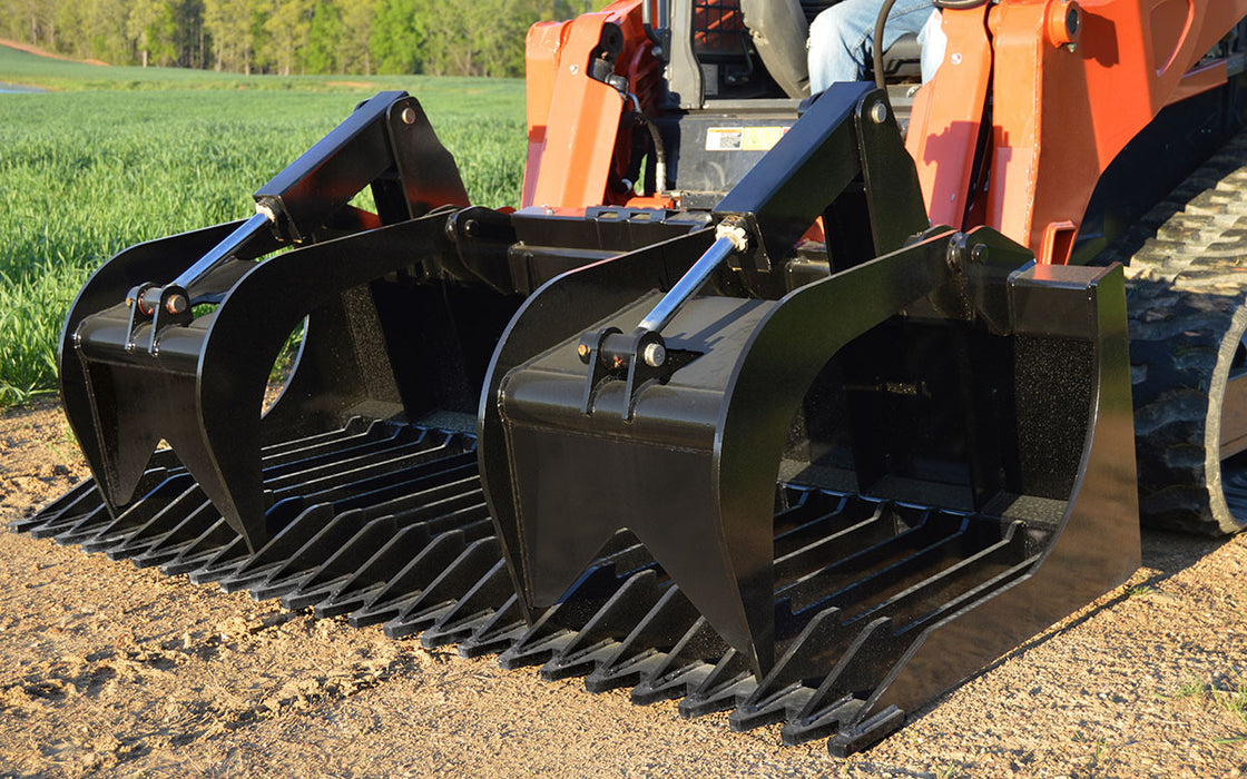 Loflin Fabrication XHD rock grapple bucket handling large rocks and debris – heavy-duty attachment built for demanding land clearing and excavation work.