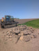 Heavy-duty tractor rock bucket mounted on a utility tractor during a landscaping and excavation project.