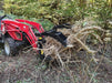 Compact tractor grapple bucket by Stinger in action clearing brush – powerful, versatile attachment for lifting, gripping, and transporting materials.