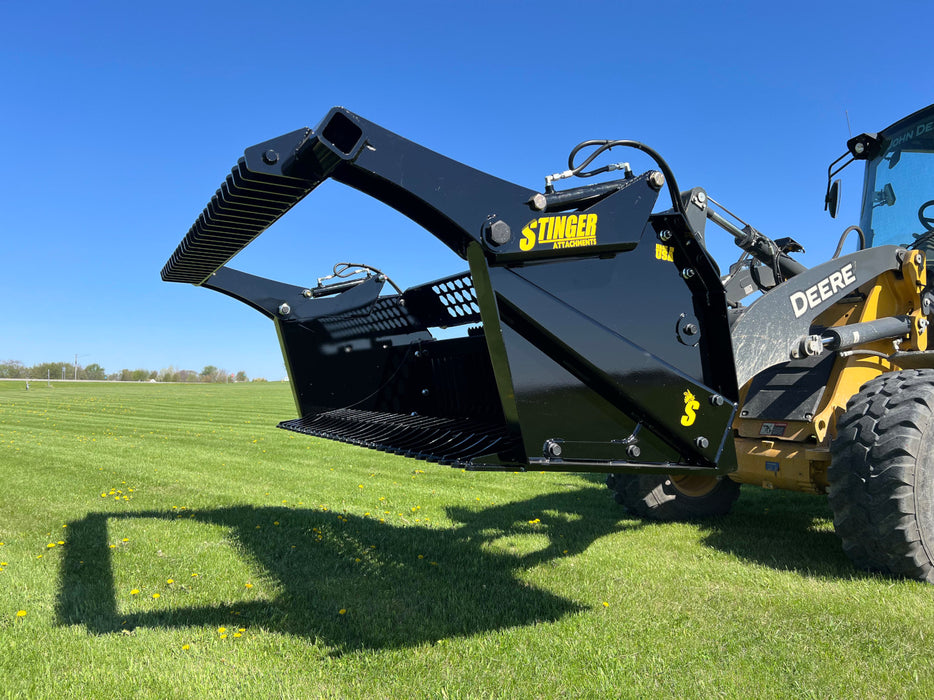 Utility tractor hauling rocks using a tractor rock bucket designed for efficient debris handling.