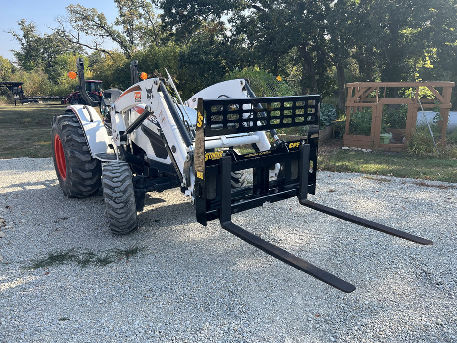 Stinger skid steer pallet fork moving hay bales on farm – strong and reliable fork attachment built for tractors and loaders.