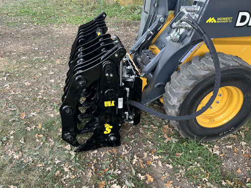 Heavy-duty Clam Grapple attachment by Stinger mounted on a utility tractor lifting logs and debris on a worksite.