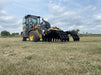 Side view of the Stinger tractor grapple bucket highlighting durable steel tines and hydraulic cylinders.