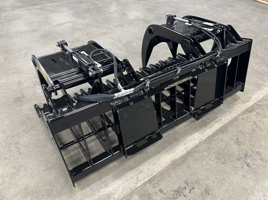 Tractor equipped with a Rock Grapple removing debris, stones, and tree roots from a rugged terrain.