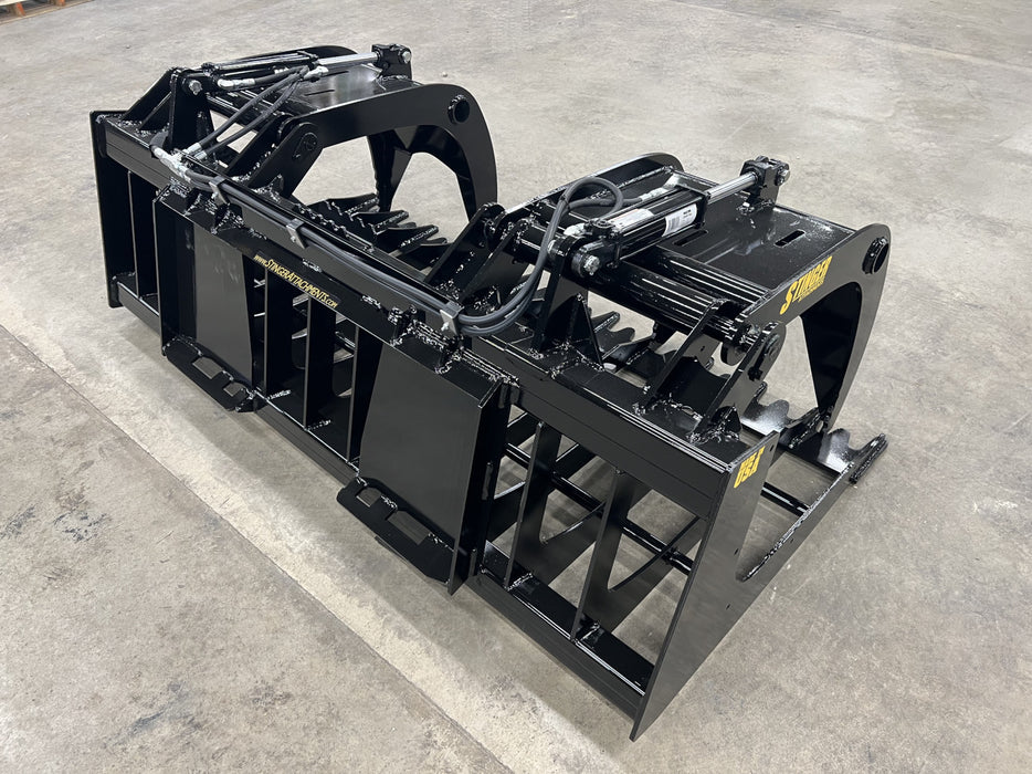 Front angle of the Rock Grapple attachment handling boulders and roots in a land clearing operation.