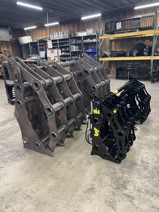 Heavy-duty tractor grapple bucket attachment in action, gripping mixed debris during a clearing operation.