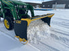 Heavy-duty skid steer snow pusher by Stinger removing snow on parking lot – designed for compact tractors and small loaders.