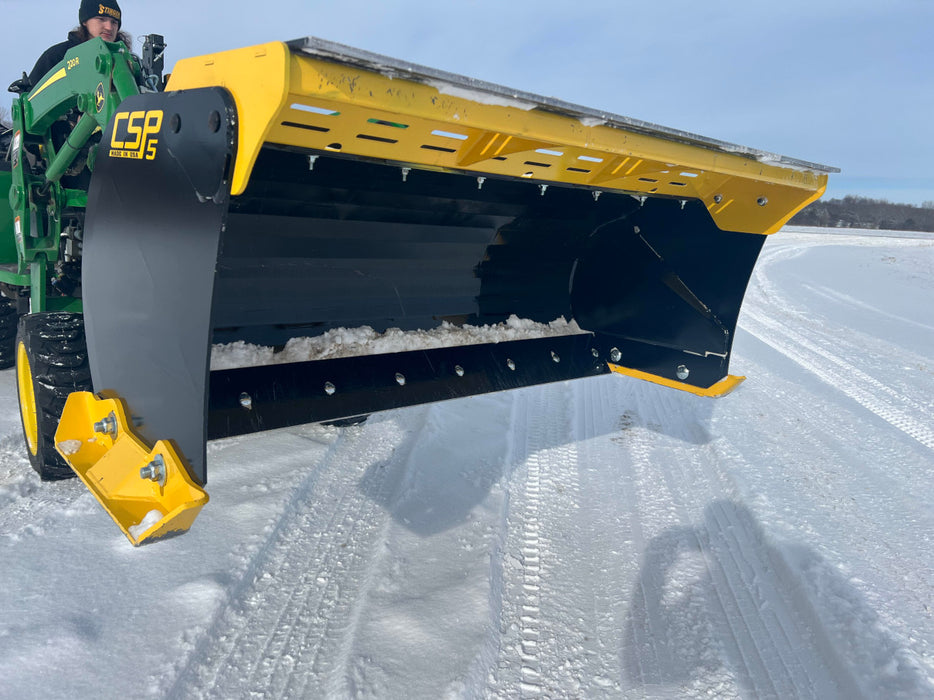 Heavy-duty compact skid steer snow pusher attached to loader – professional-grade attachment for winter road and lot maintenance.